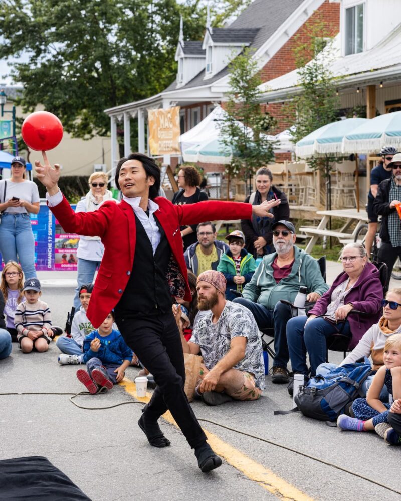 a man in a red suit and black suit holding a red ball